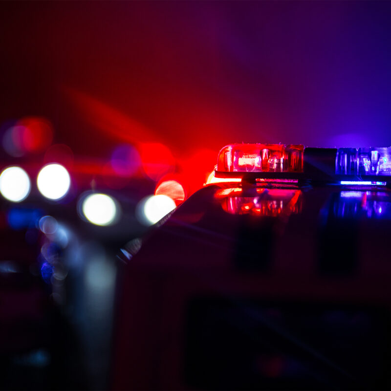 Police car chasing a car at night with fog background. 911 Emergency response police car speeding to scene of crime. Selective focus