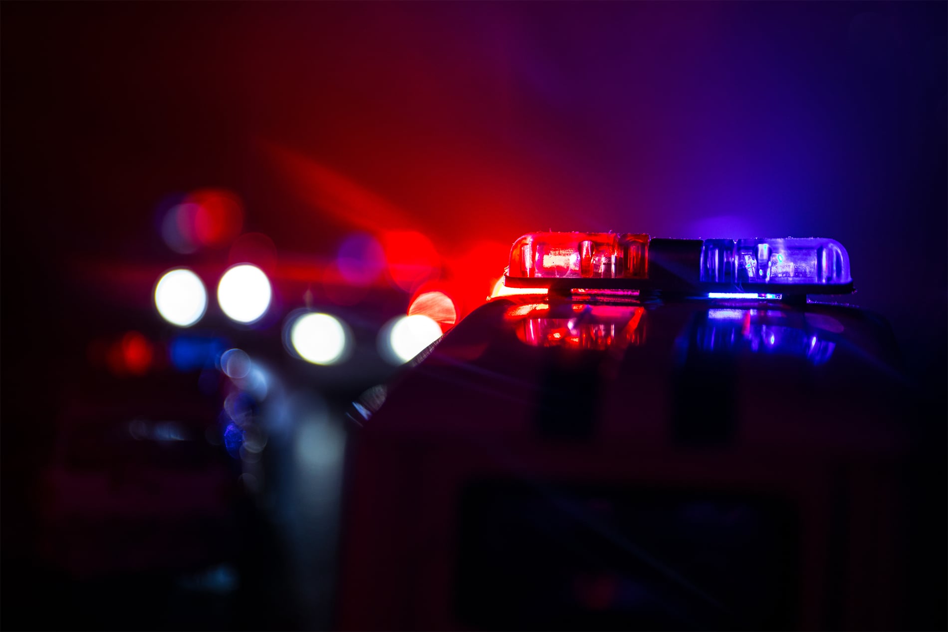 Police car chasing a car at night with fog background. 911 Emergency response police car speeding to scene of crime. Selective focus